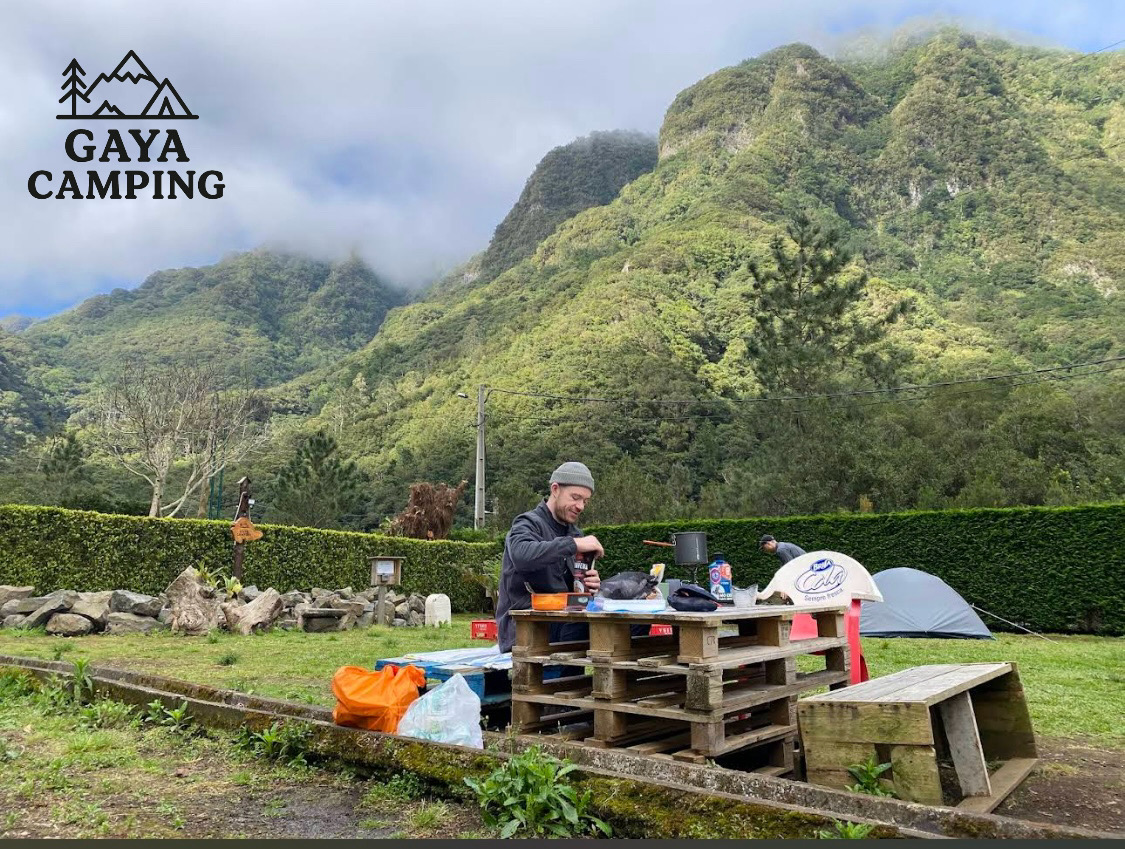 Gaya Camping com logo e paisagem montanhosa